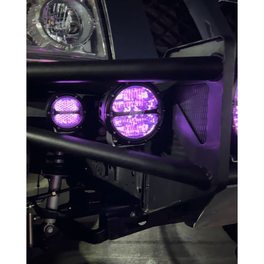Purple LED off-road lights mounted on a vehicle bumper, glowing with vibrant illumination.