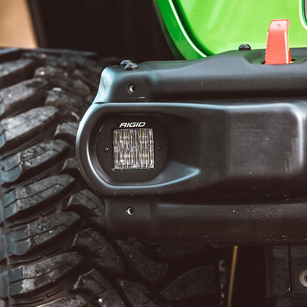 Rigid LED light mounted on black off-road vehicle bumper near rugged tire
