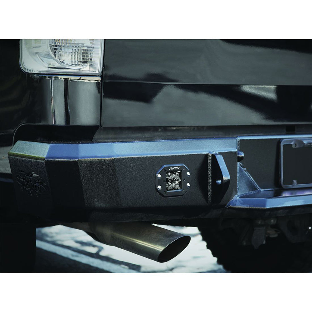Rigid LED light mounted on black truck front bumper with exhaust pipe visible