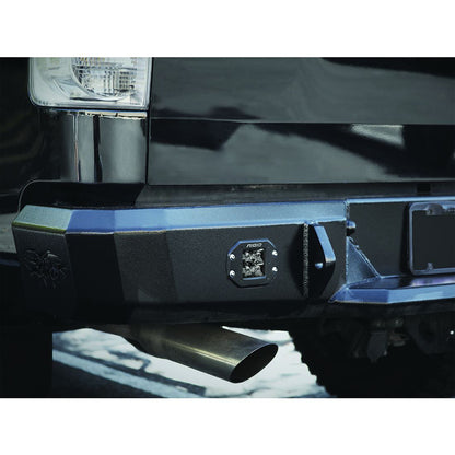 Rigid LED light mounted on black truck front bumper with exhaust pipe visible