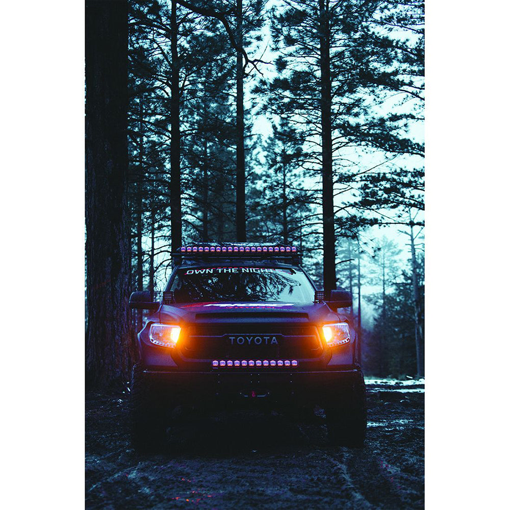 Toyota truck with LED light bar and custom lighting in forest at night, showcasing off-road styling