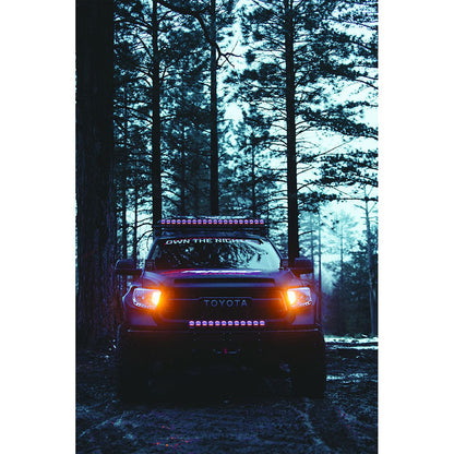 Toyota truck with LED light bar and off-road lights in forest at night, showcasing custom auto lighting installation