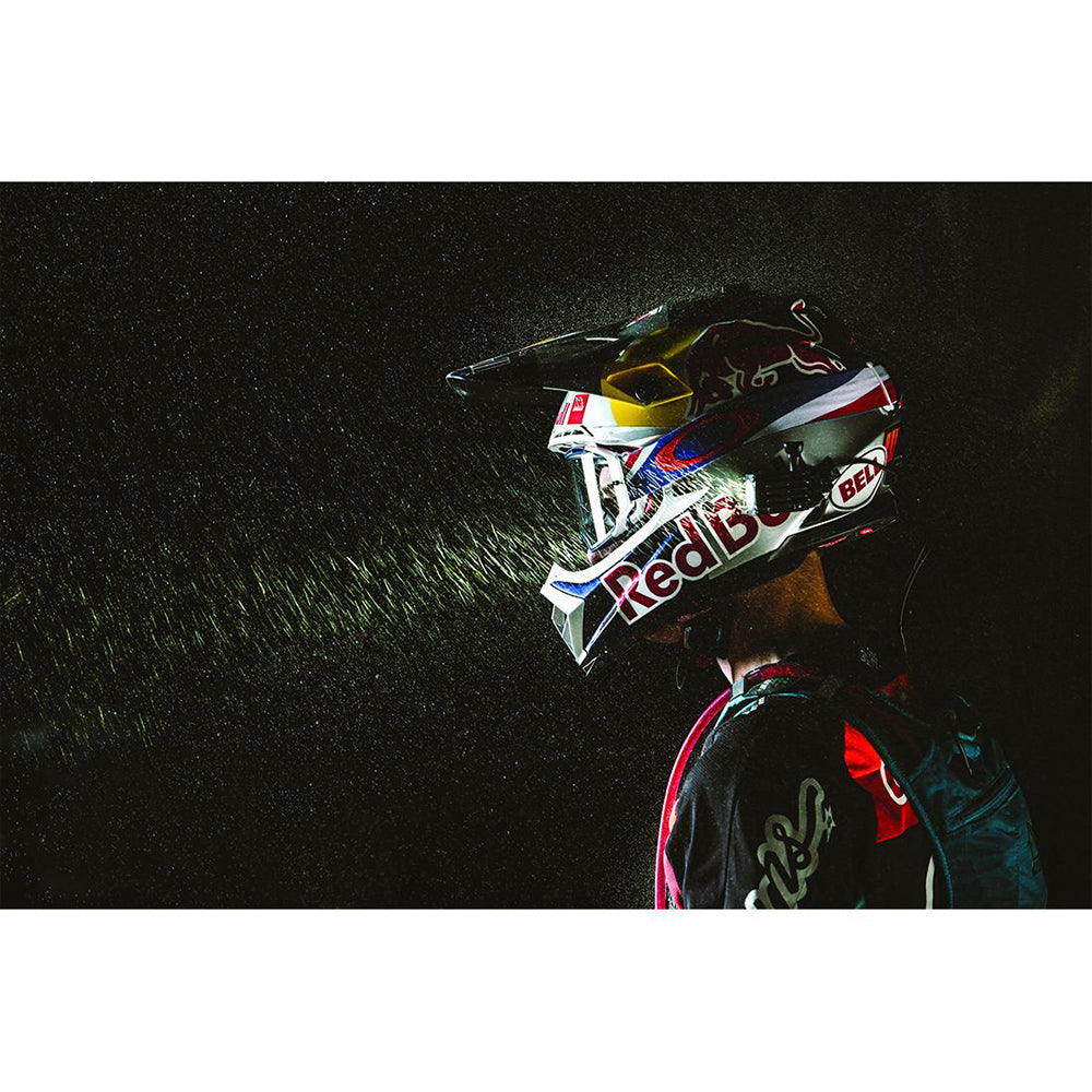 Red Bull motocross helmet with Bell branding, worn by rider in action under spotlight