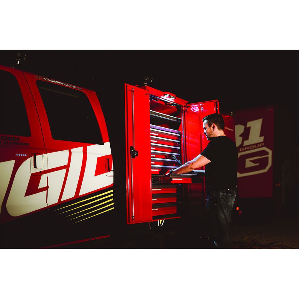 Mechanic accessing tools in red mobile workshop van with illuminated drawers