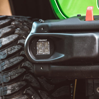 Rigid LED light mounted on black off-road vehicle bumper near rugged tire