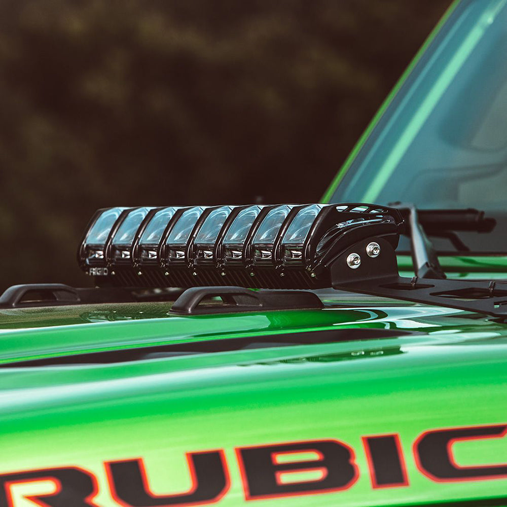 Rigid LED light bar mounted on green Jeep Rubicon roof for off-road illumination