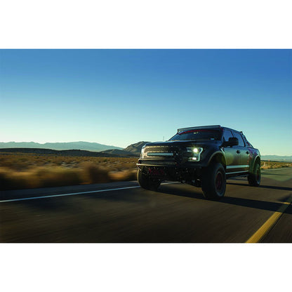 Black off-road truck with LED lights driving on desert highway, showcasing custom auto styling and performance upgrades.