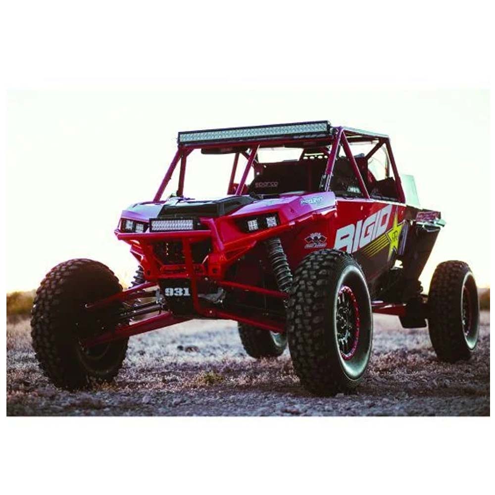 Red off-road UTV with LED lights and rugged tires on dirt terrain